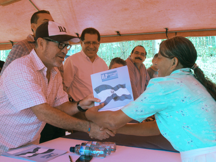 El Director Ejecutivo del ILP, David Henríquez entrega a Claudia Irma Berríos su título de propiedad. Ella fue una de las 98 familias de la Comunidad San José Las Flores que a partir de ese día cuenta con seguridad jurídica.